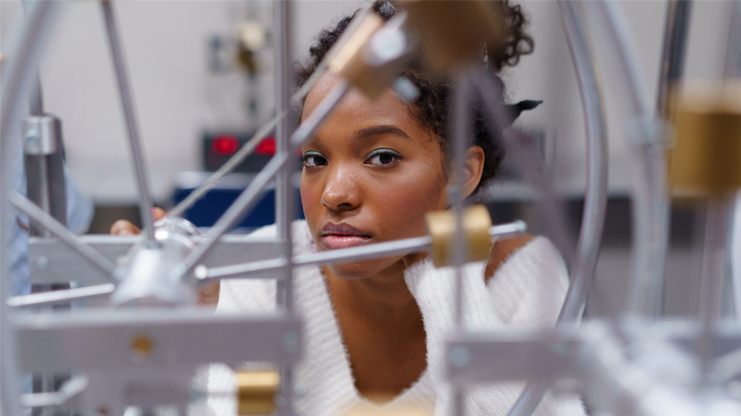 student looks through a structure built in a lab